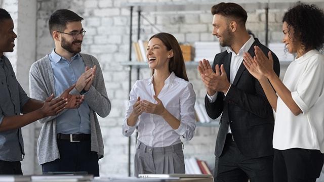 A group of business people congratulating their coworker