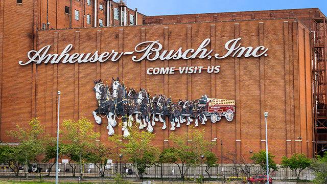 Side of a brick Anheuser-Busch building with image of horse team pulling a beer wagon